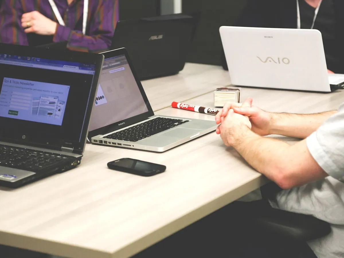 Colleagues working on laptops around a meeting table